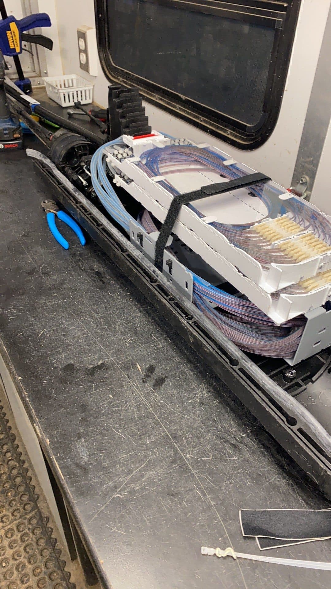 Fiber splice trays and a closure laid out on the workbench inside a Miller Optical splice trailer